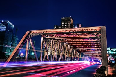 远处有高层建筑的桥上车辆的时间推移和光条纹照片